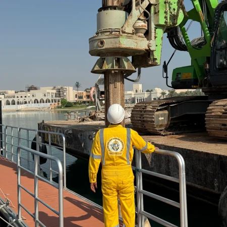 Vertical steel pipeline positioned at jetty edge during installation
