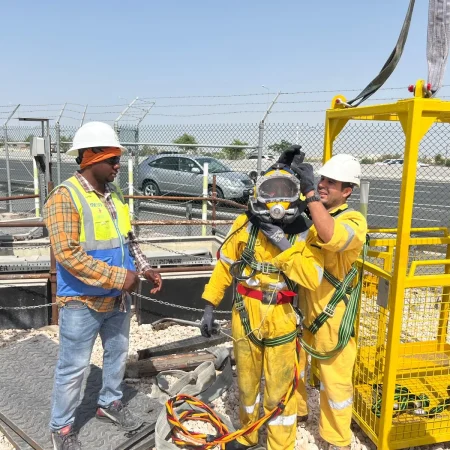 Confined-space marine maintenance works at Muntazah Road Underpass involving commercial divers, lifting cage, and removal of submersible pumping equipment