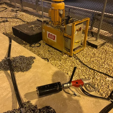 Confined-space marine maintenance works at Muntazah Road Underpass involving commercial divers, lifting cage, and removal of submersible pumping equipment.