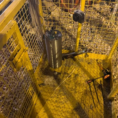 Confined-space marine maintenance works at Muntazah Road Underpass involving commercial divers, lifting cage, and removal of submersible pumping equipment.