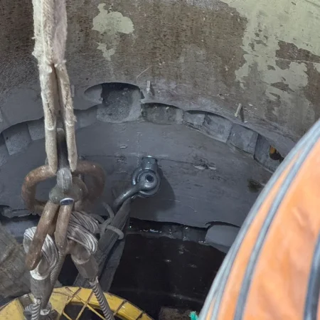 Confined space mechanical works at PS30 showing core drilling and installation of 1000mm diameter air recirculation duct within reinforced concrete shaft.