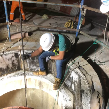 Confined space mechanical works at PS30 showing core drilling and installation of 1000mm diameter air recirculation duct within reinforced concrete shaft.