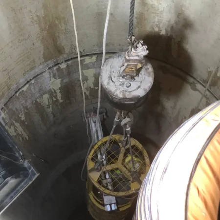 Confined space mechanical works at PS30 showing core drilling and installation of 1000mm diameter air recirculation duct within reinforced concrete shaft.