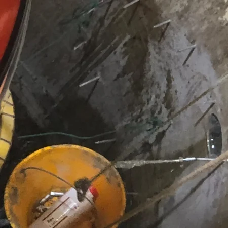 Confined space mechanical works at PS30 showing core drilling and installation of 1000mm diameter air recirculation duct within reinforced concrete shaft.